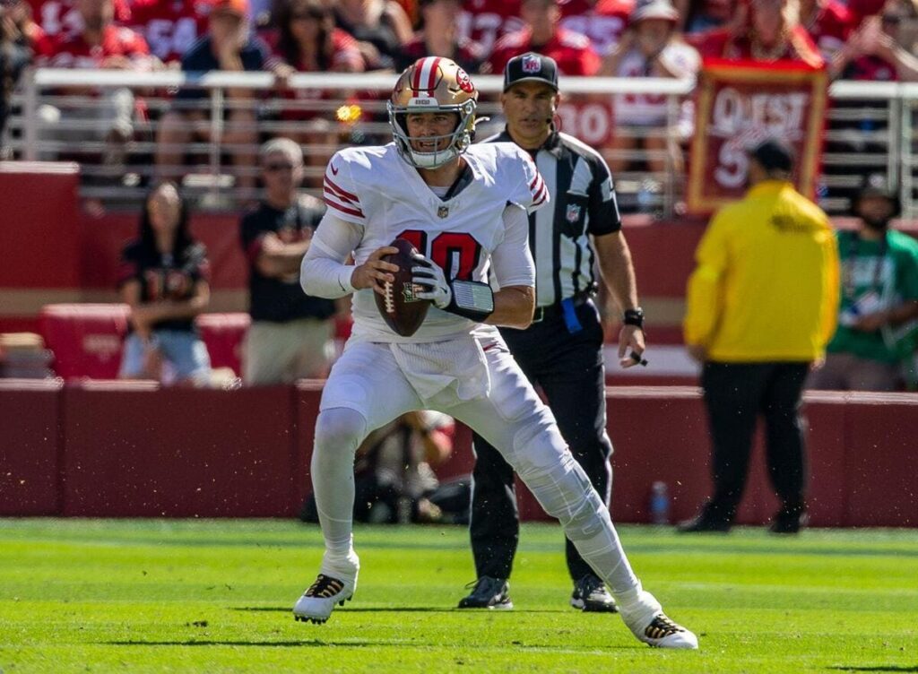 San Francisco 49ers quarterback Mac Jones with a football during a game.