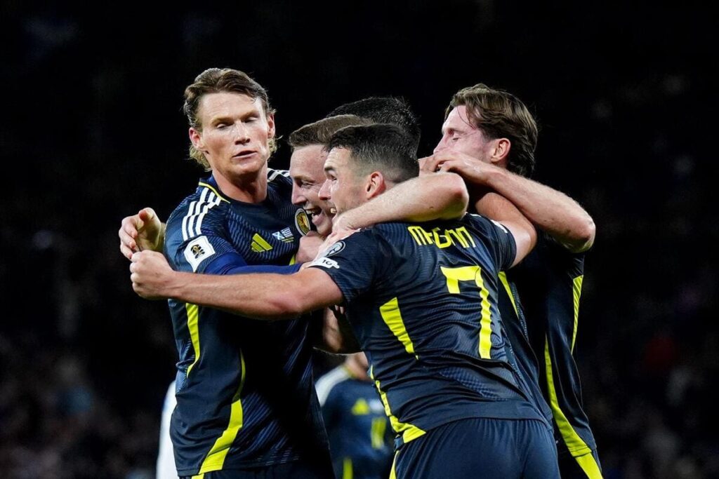 Players from the Scotland national football team celebrate a goal in a match
